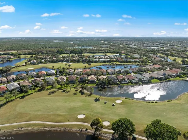 Aerial view of property and surrounding area with nearby suburban area, a nearby body of water, and a golf club