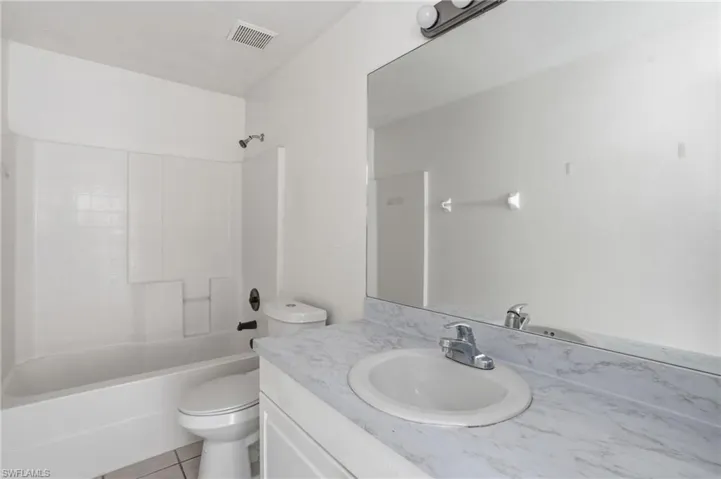 Full bath featuring vanity, bathing tub / shower combination, and light tile patterned floors
