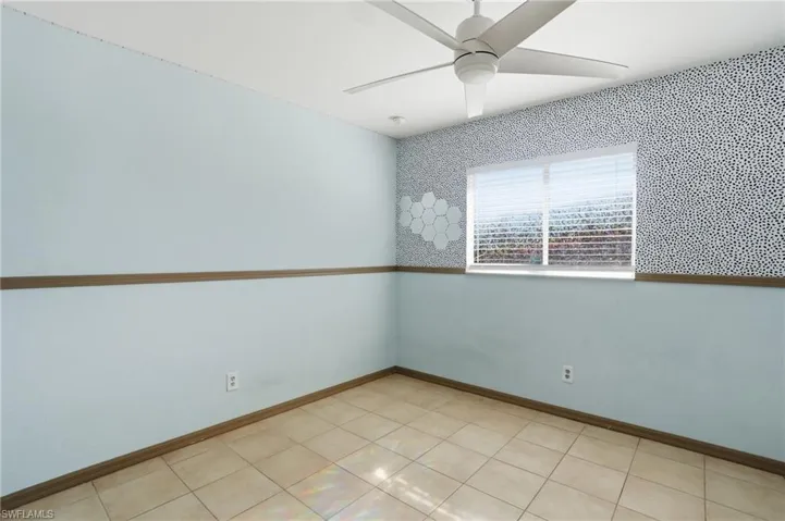 Spare room with a ceiling fan and baseboards