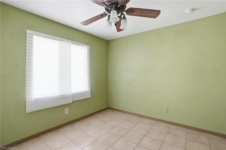 Unfurnished room with a ceiling fan and light tile patterned flooring