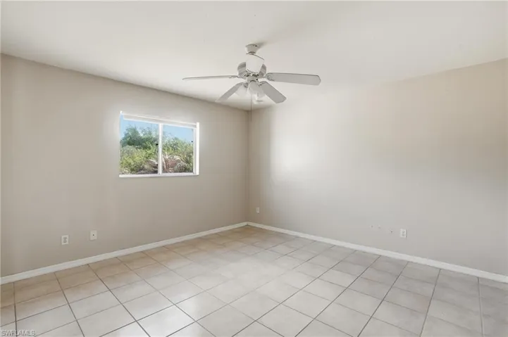 Spare room featuring ceiling fan and baseboards