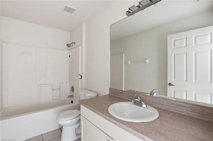 Full bath featuring vanity, shower / tub combination, and light tile patterned floors
