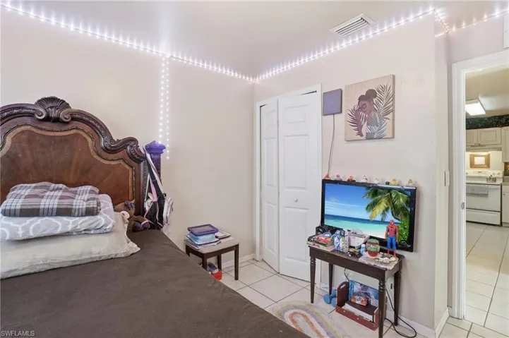 Bedroom with light tile patterned floors and a closet