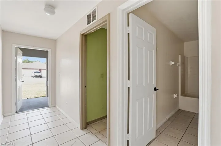 Hallway with light tile patterned floors and baseboards