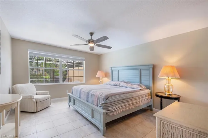 Bedroom featuring light tile patterned flooring, a textured ceiling, and ceiling fan