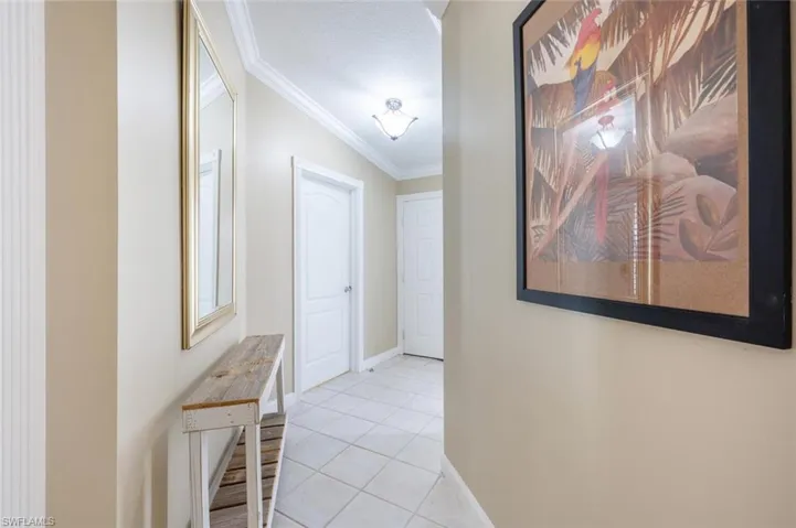Hall featuring crown molding and light tile patterned floors