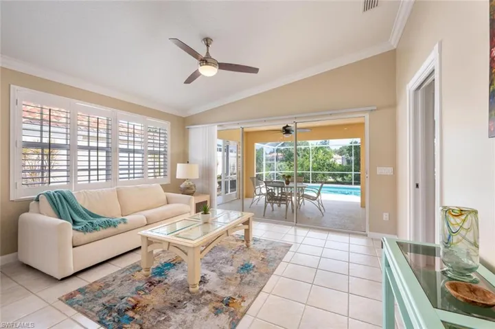 Living room with plenty of natural light, ceiling fan, lofted ceiling, and ornamental molding