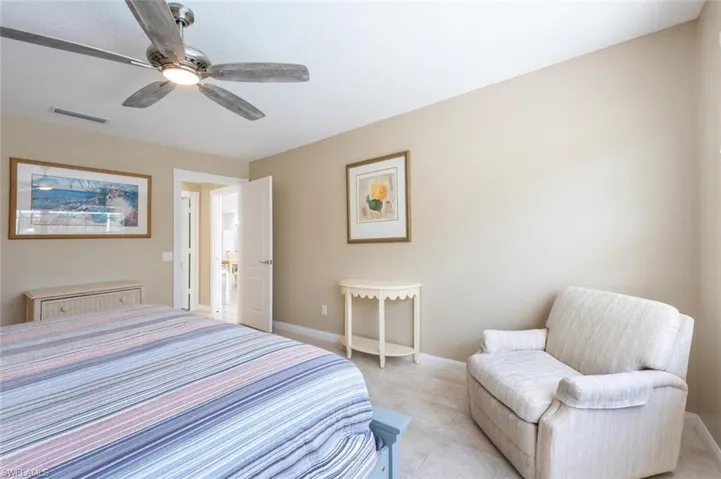 Tiled bedroom featuring ceiling fan