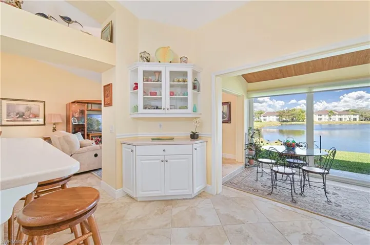 Kitchen featuring white cabinetry, glass insert cabinets, light countertops, and open floor plan