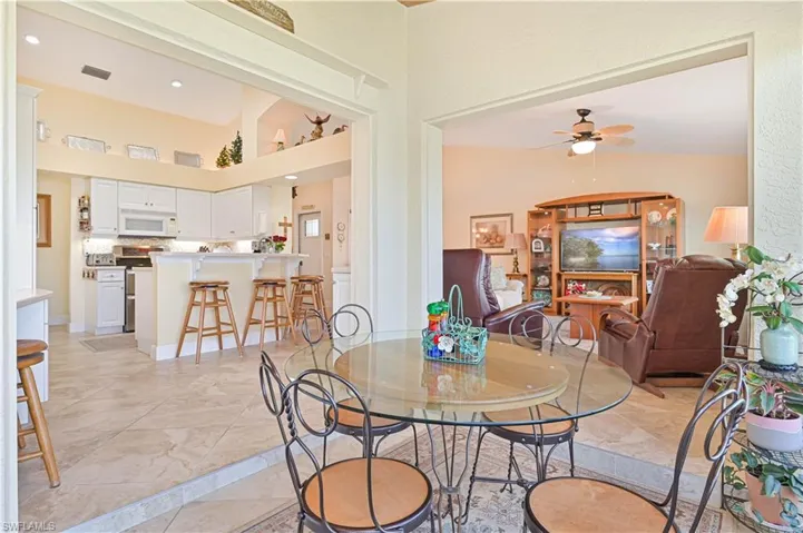 Dining area with ceiling fan, recessed lighting, and a high ceiling