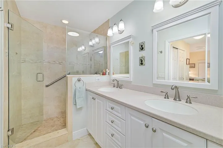 Full bath featuring a stall shower and double vanity