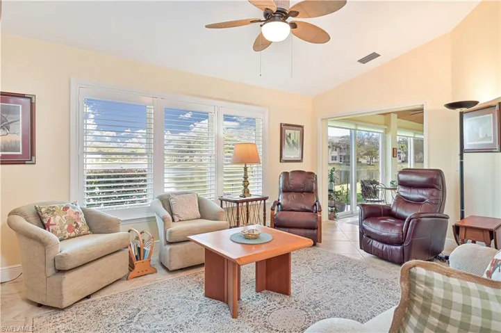 Living area with healthy amount of natural light, lofted ceiling, and ceiling fan