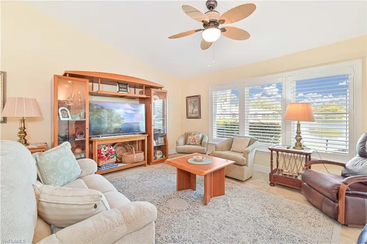 Living room featuring ceiling fan and vaulted ceiling
