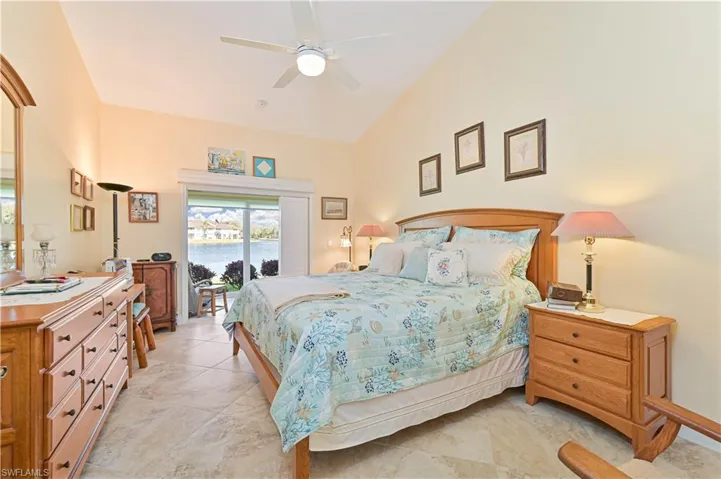 Bedroom with access to exterior, a ceiling fan, and lofted ceiling