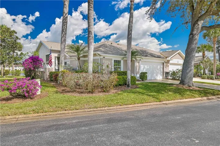 View of front facade with an attached garage, stucco siding, concrete driveway, and a front lawn
