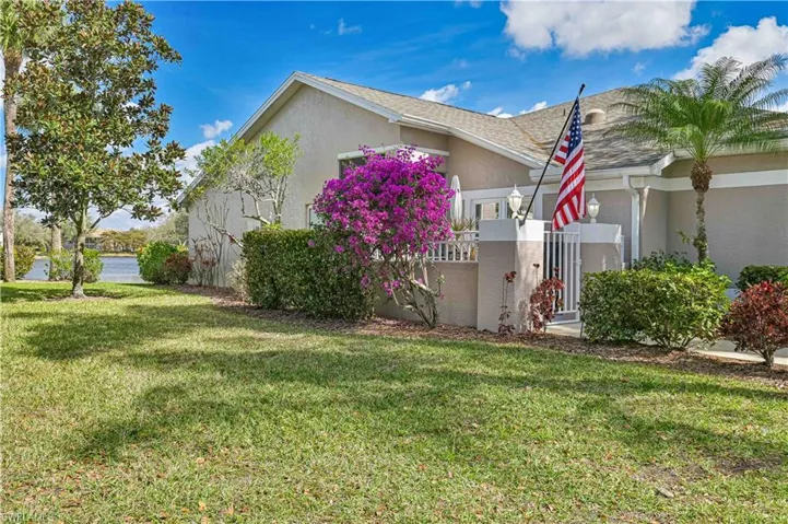 View of property exterior with stucco siding and a lawn