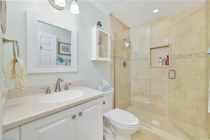 Full bath featuring vanity, a shower stall, crown molding, and recessed lighting