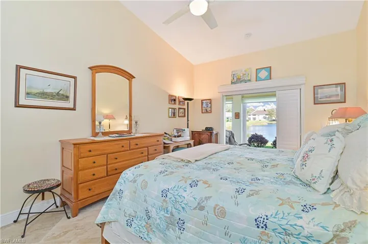 Bedroom with access to outside, vaulted ceiling, and ceiling fan