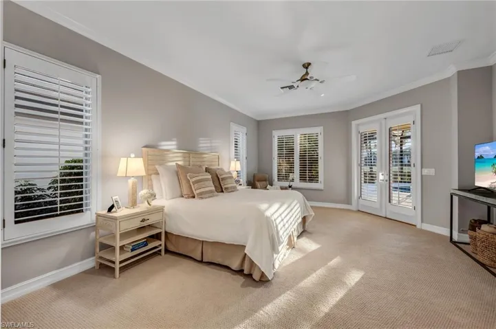 he spacious primary suite has beautiful views out to the pool and golf course.