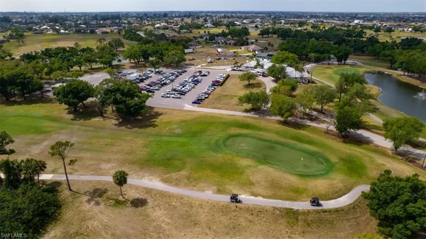 Aerial overview of property's location featuring a golf course and a large body of water