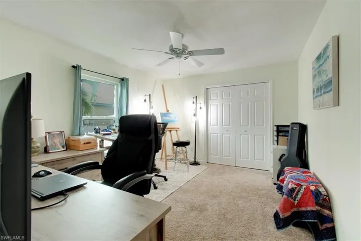 Office space with light colored carpet and a ceiling fan