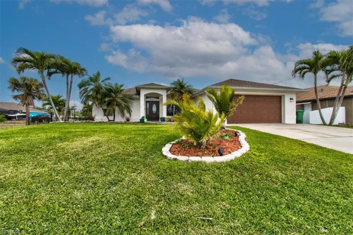 View of front of house with concrete driveway, stucco siding, and an attached garage