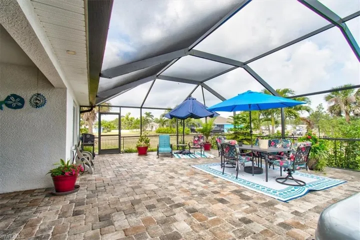 View of patio featuring a sunroom, a lanai, and outdoor dining area
