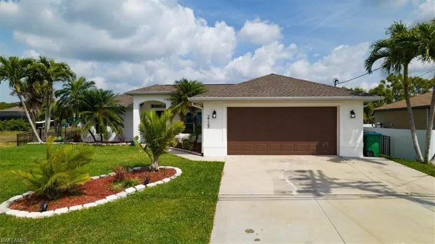 View of front of house with concrete driveway, a garage, roof with shingles, and stucco siding