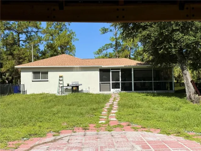 Back of property featuring a lawn and a sunroom