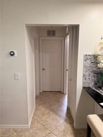 Corridor featuring light tile patterned flooring