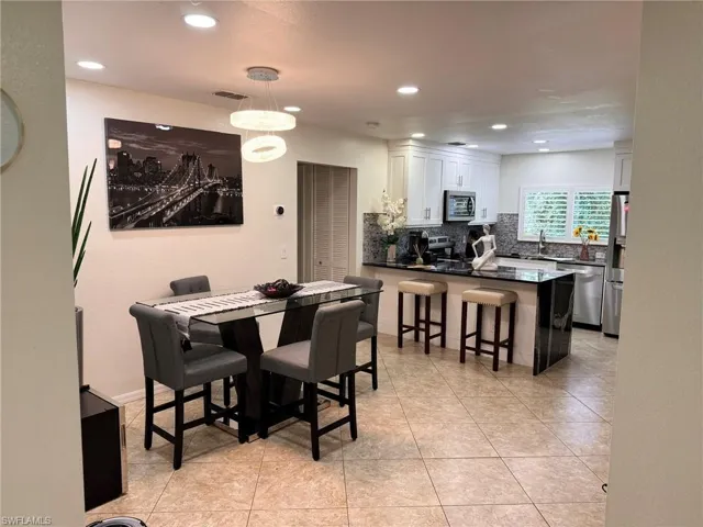 Dining area featuring sink and light tile patterned floors