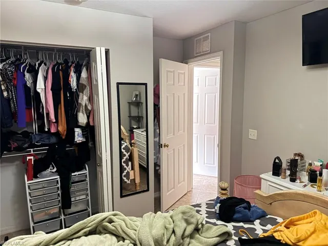 Bedroom with light tile patterned flooring and a closet