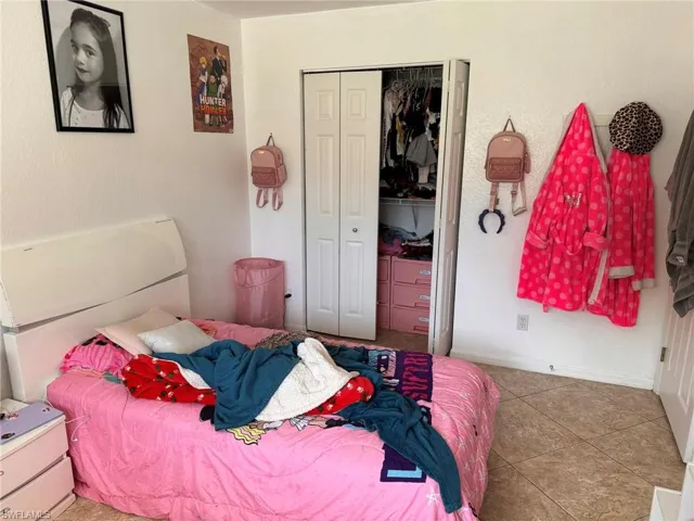 Bedroom featuring tile patterned floors and a closet