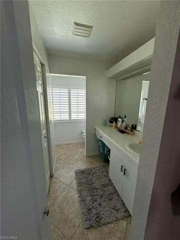 Bathroom featuring vanity, a textured ceiling, and tile patterned flooring