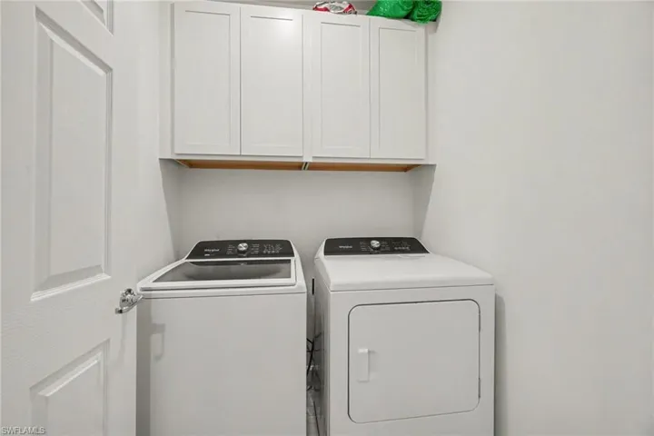 Laundry area featuring white shaker-style cabinetry, a top-load washing machine, and a front-load dryer