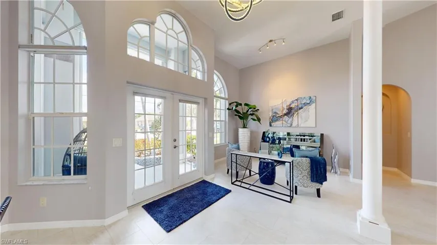 Foyer entrance with a high ceiling, french doors, and arched walkways