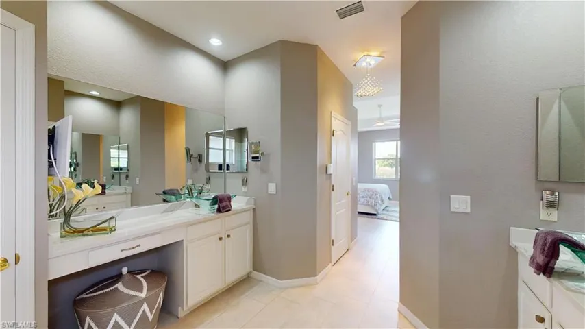 Full bath featuring ensuite bath, two vanities, a ceiling fan, and light tile patterned floors