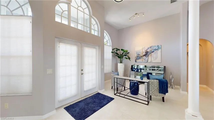 Entrance foyer featuring french doors, ornate columns, and arched walkways