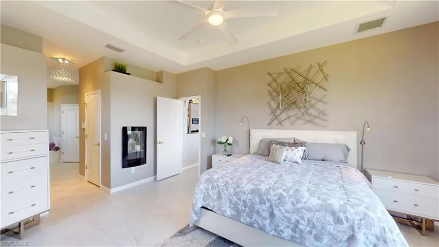 Bedroom featuring a raised ceiling, a closet, a ceiling fan, and light floors