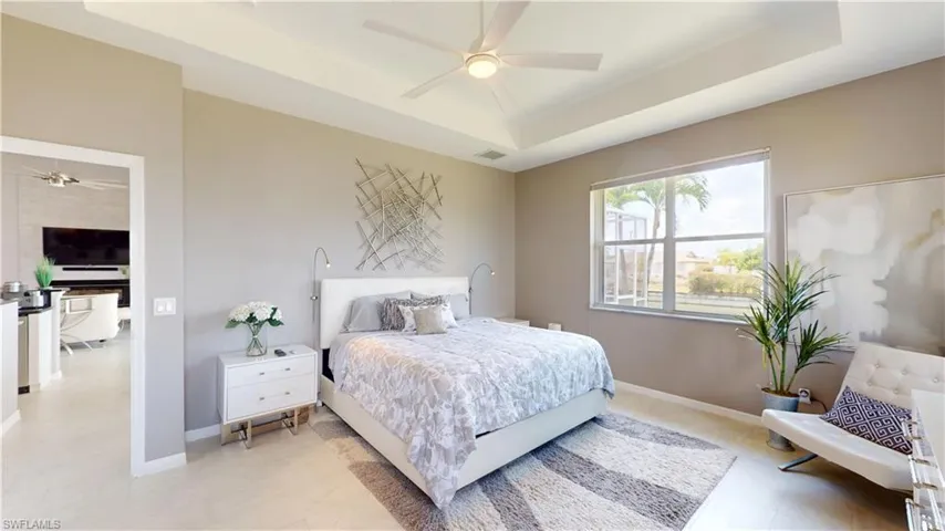 Bedroom with a tray ceiling and a ceiling fan