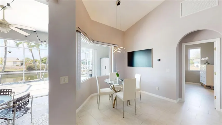 Dining space with arched walkways, a ceiling fan, healthy amount of natural light, and vaulted ceiling