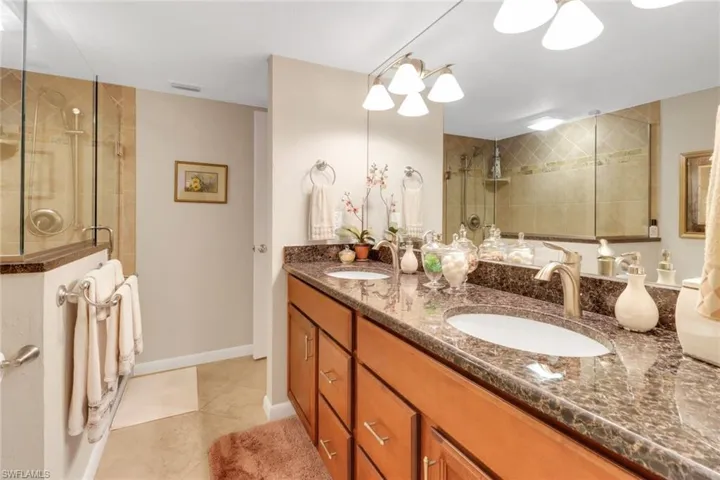 Bathroom with an enclosed shower, vanity, and tile patterned floors