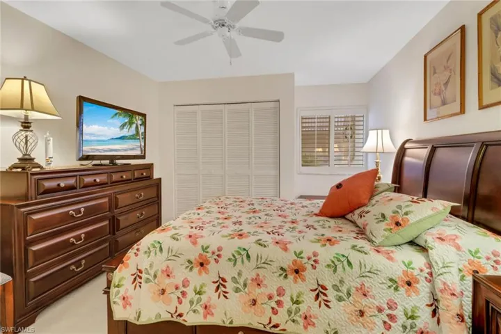 Bedroom featuring light carpet, ceiling fan, and a closet