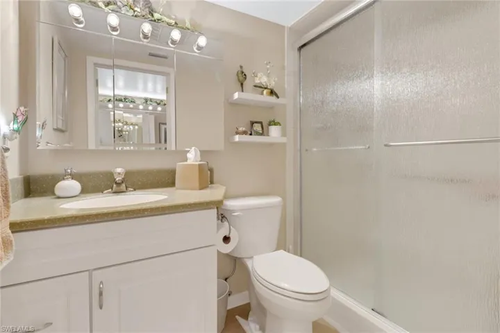 Bathroom with vanity, toilet, and an enclosed shower