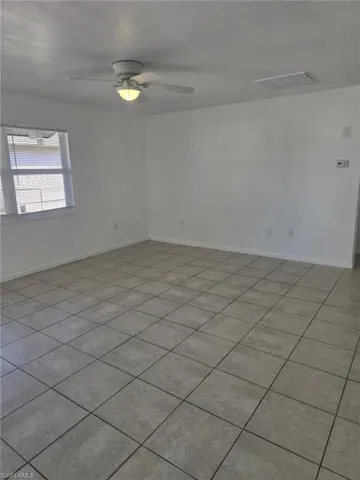 Spare room featuring ceiling fan and light tile patterned flooring
