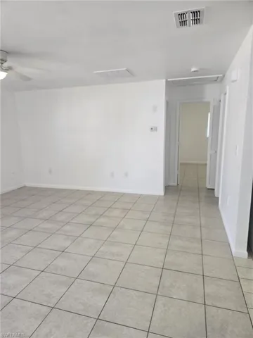 Unfurnished room with light tile patterned floors and a ceiling fan