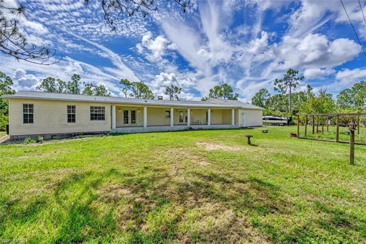 Back of property featuring a lawn