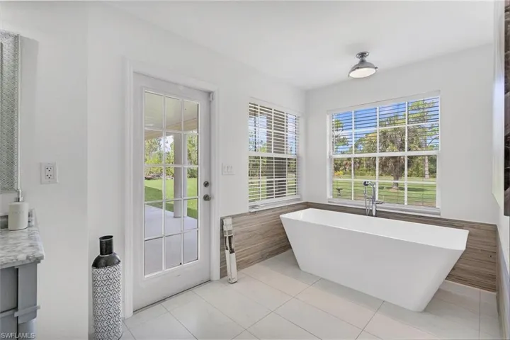 Bathroom with vanity, a bath, and tile patterned floors