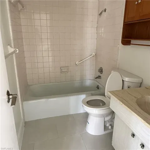Full bath with vanity, shower / bath combination, and light tile patterned floors