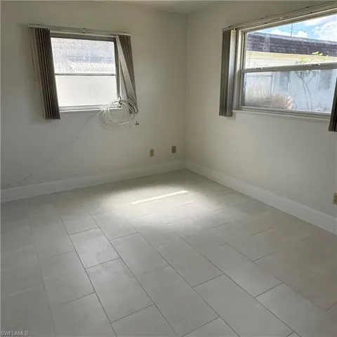 Empty room with plenty of natural light and light tile patterned floors
